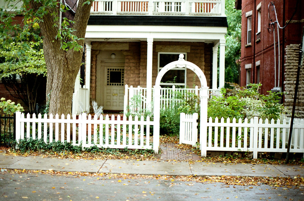 White picket fence and garden gate in front of a character home